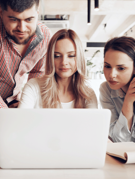 image-(1)-(2)1_0002_two-female-one-male-business-partners-looking-computer-screen-discussing-their-project