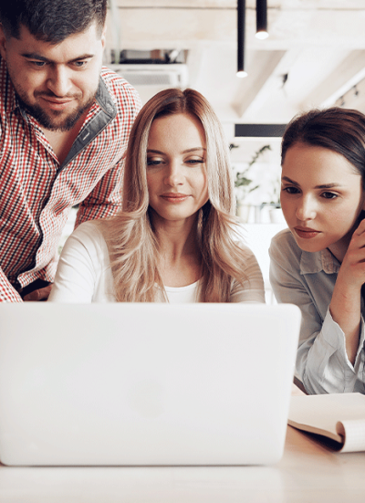 image-(1)-(2)1_0002_two-female-one-male-business-partners-looking-computer-screen-discussing-their-project